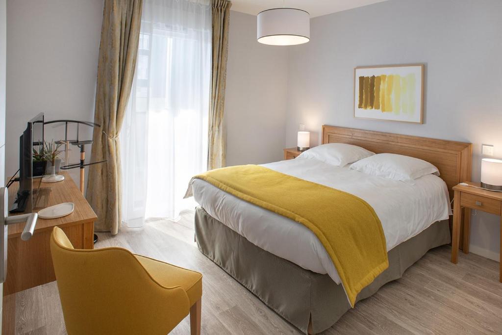1 dormitorio con 1 cama grande con manta amarilla en DOMITYS - Les Vergers d'Ebène, en Agen