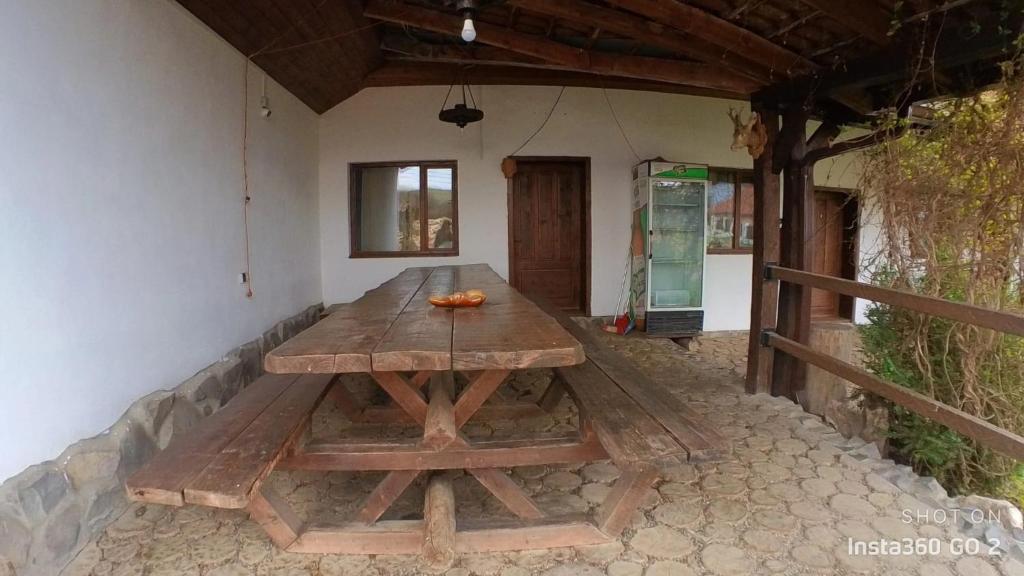 a wooden table sitting on a stone floor in a patio at Vila Sura Razoare in Sighişoara