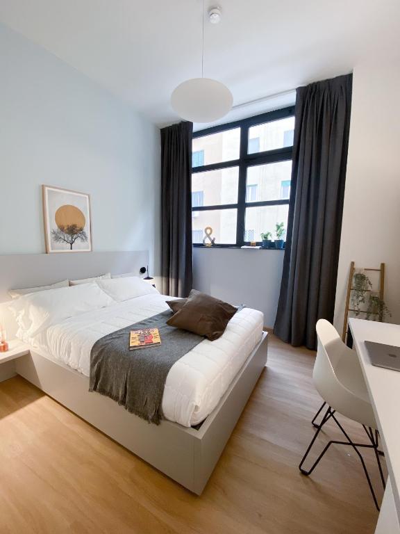 a bedroom with a bed and a desk and a window at Dotcampus Roma City Center in Rome