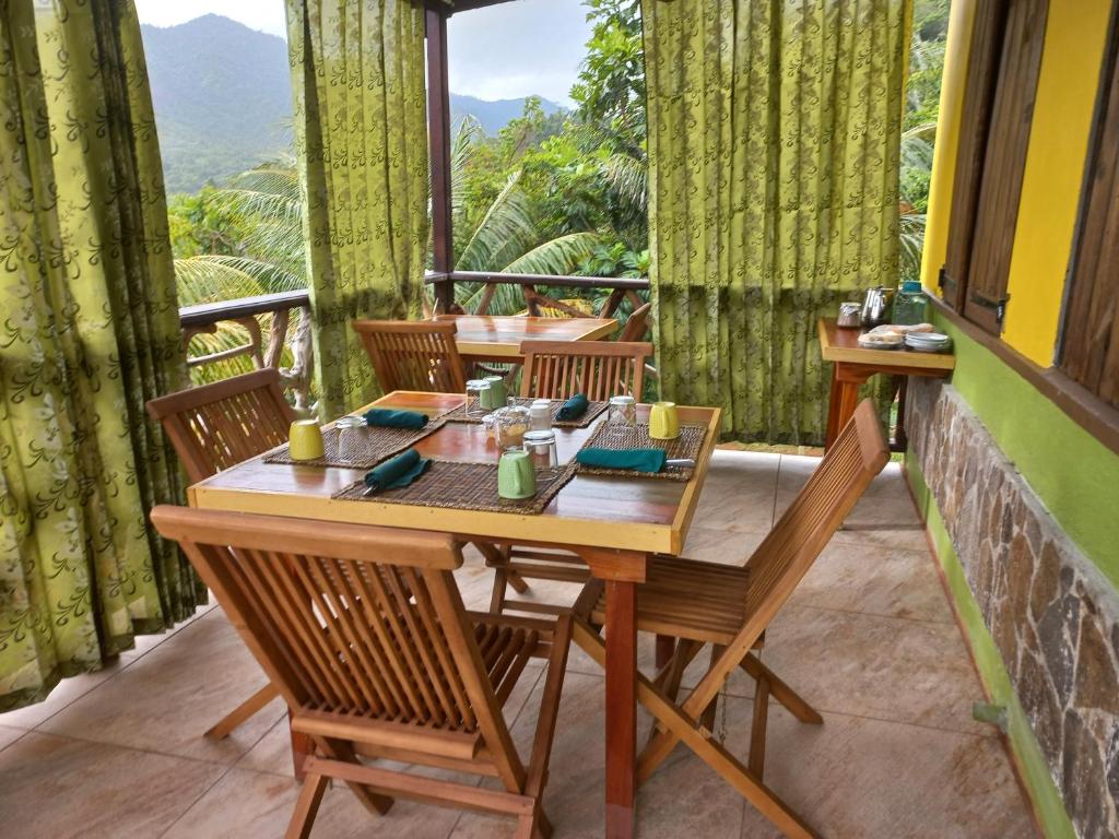 einen Tisch und Stühle auf einem Balkon mit Aussicht in der Unterkunft Serenity Lodges Dominica in Marigot