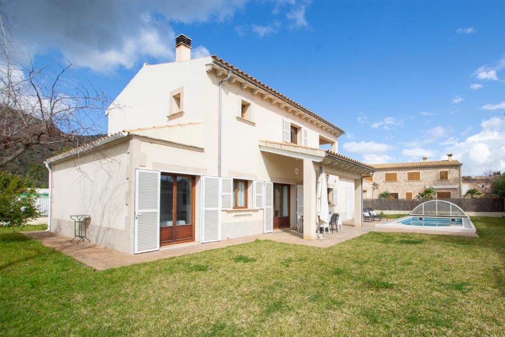 una casa blanca con piscina en el patio en Villa Nelly, en Alcudia