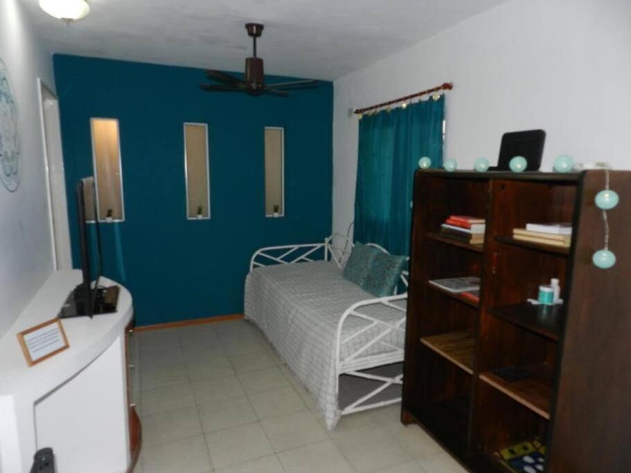 - une chambre avec un lit et un mur bleu dans l'établissement Viví Rosario, à Rosario