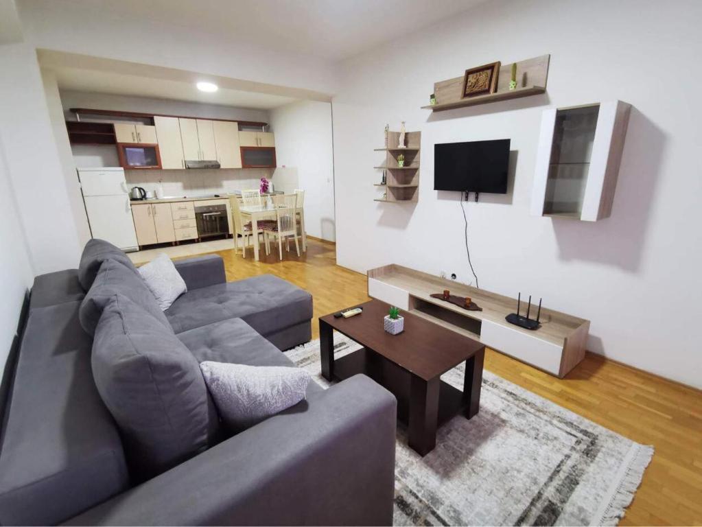 - un salon avec un canapé gris et une table dans l'établissement VD Apartment, à Skopje