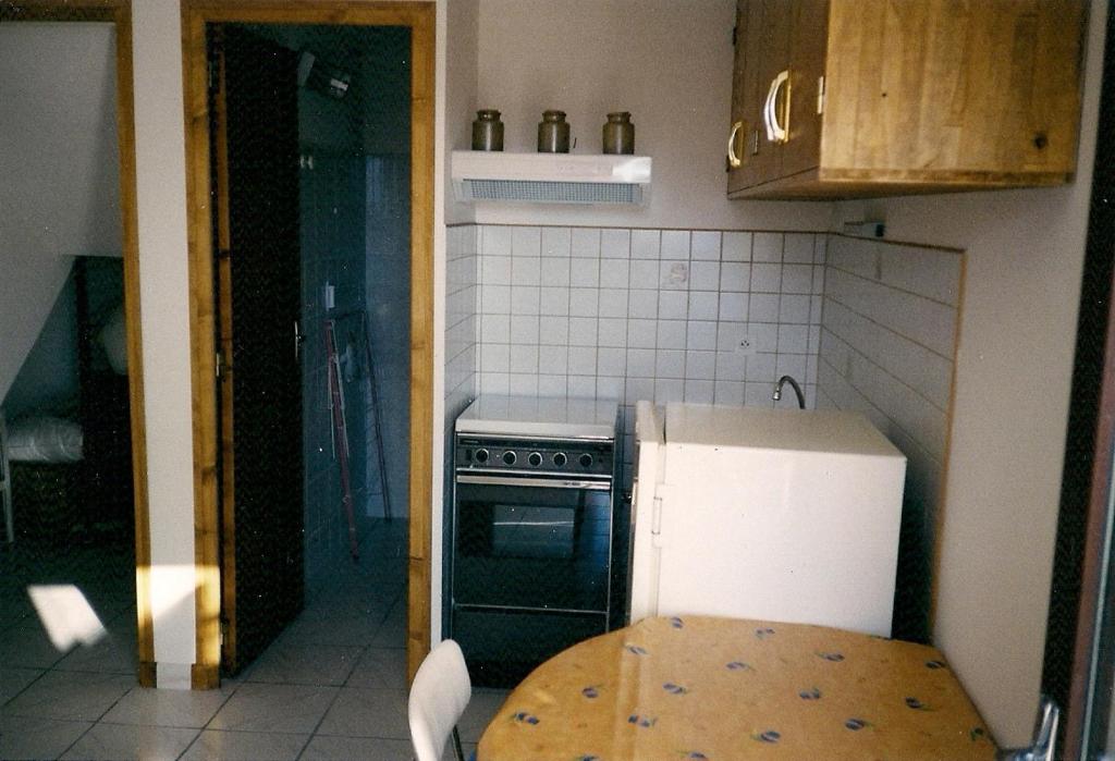 a kitchen with a refrigerator and a table in it at Mireille in Castellane