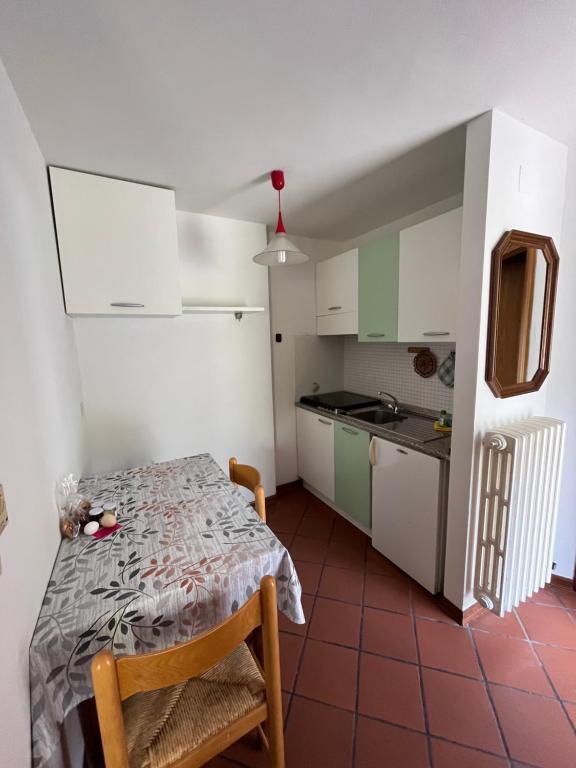 una piccola cucina con tavolo in una stanza di DOLOMITI HOUSE 12 a Fiera di Primiero