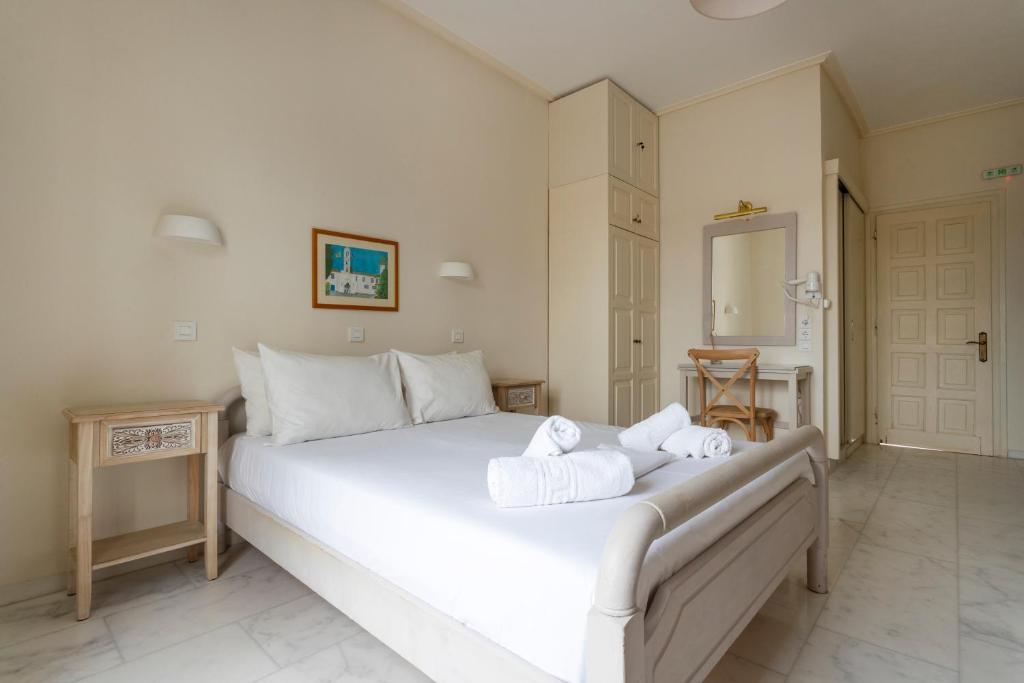 a bedroom with a large white bed with towels on it at Villa Kalomira in Spetses