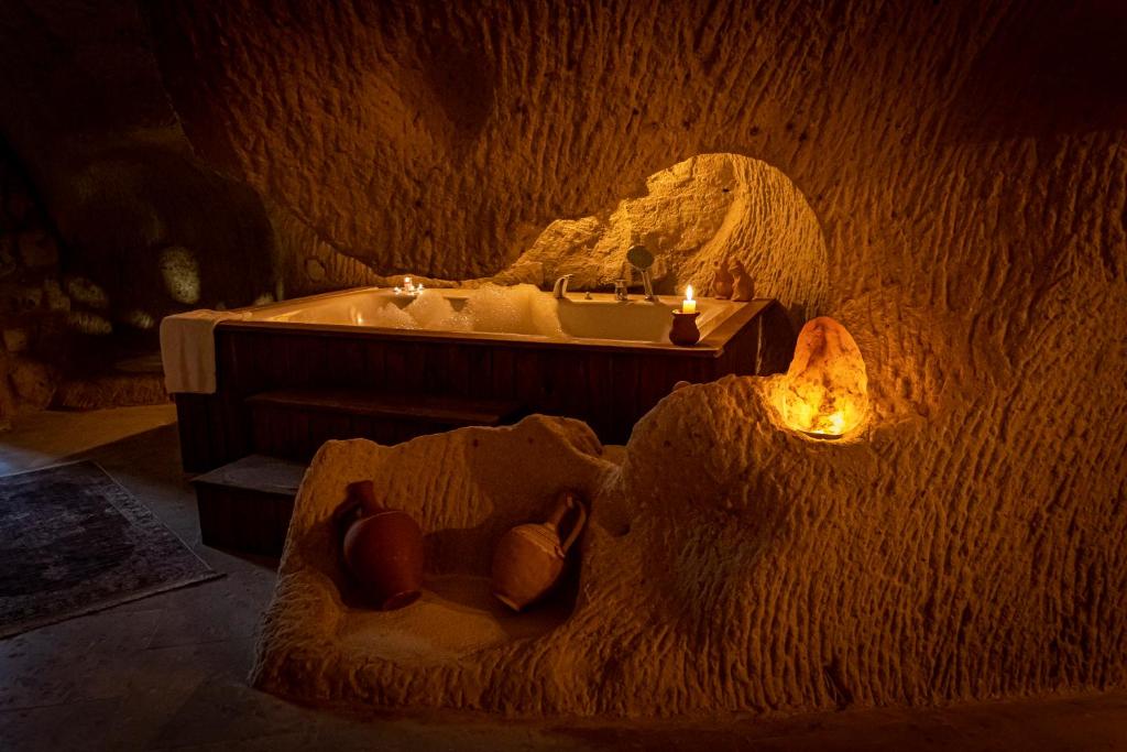 ein Badezimmer mit einer Badewanne und einem Waschbecken mit Kerzen in der Unterkunft feris cave hotel in Ürgüp