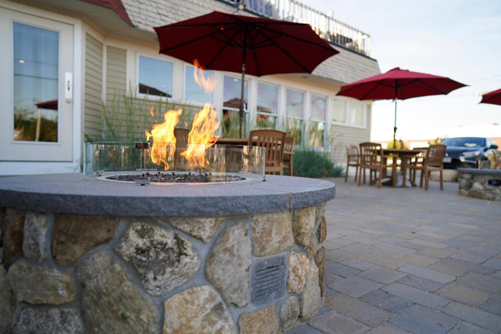 a fire pit in front of a house with umbrellas at Portside Tavern in Hyannis