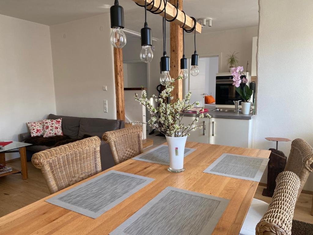 een eetkamer met een houten tafel en een keuken bij Ferienwohnung Roth, Unlingen in Unlingen