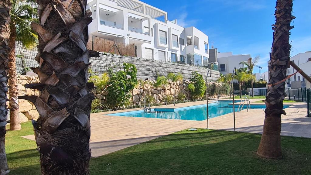 un edificio con piscina frente a un edificio en Piso Baviera Golf Costa del Sol en Caleta de Vélez