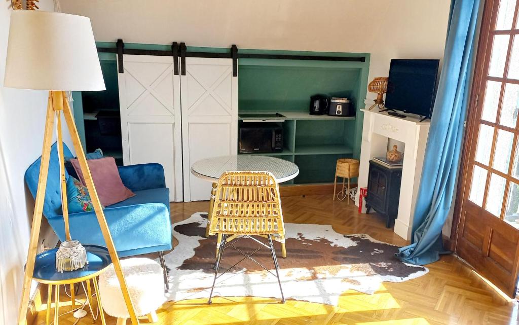 - un salon avec un canapé bleu et une table dans l'établissement Gîte L'Escalier des Rêves - Rouen, à Le Mesnil-Esnard