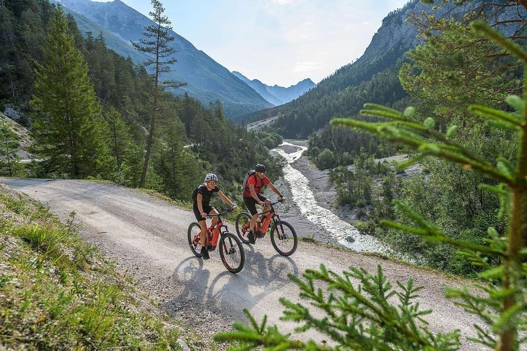 two people riding bikes on a dirt road in the mountains at Appartement Wettersteinblick in Seefeld in Tirol