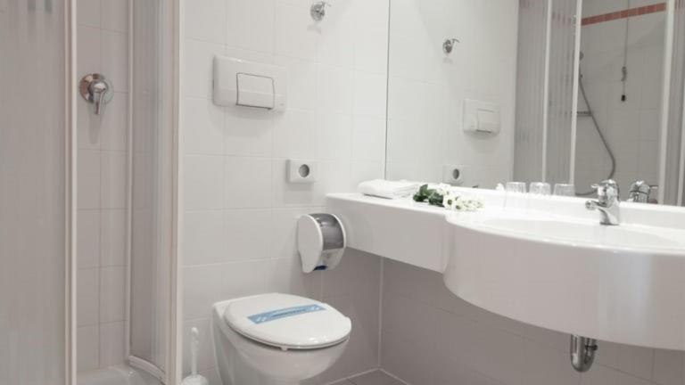 un bagno bianco con un water e un lavandino di Hotel Corno Bianco a Nova Ponente