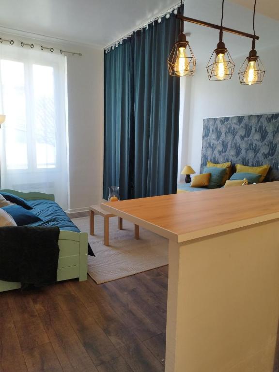 - un salon avec une table à manger et des rideaux bleus dans l'établissement Chic' Studio, à Cavaillon