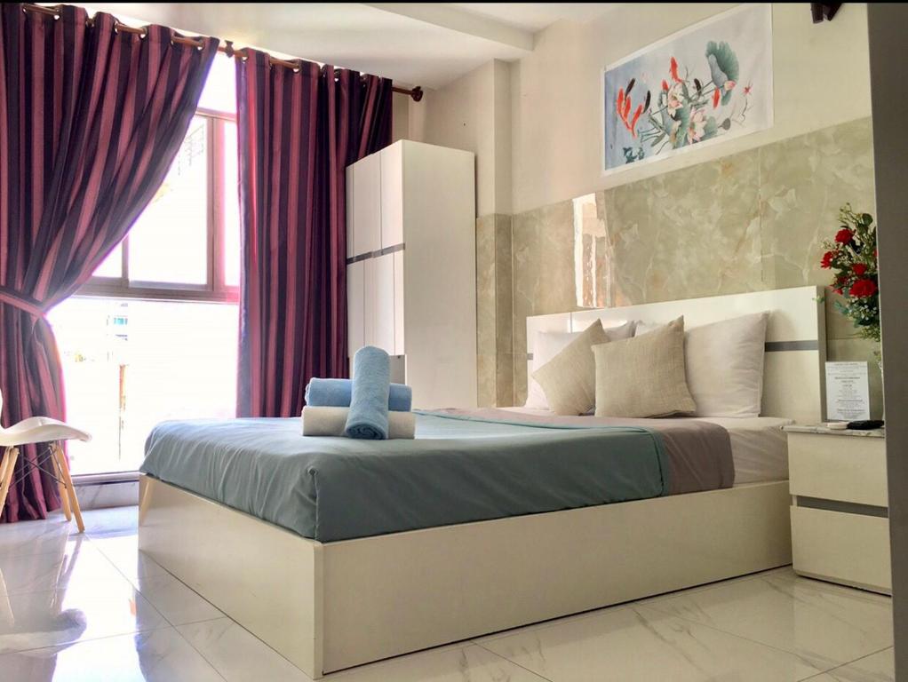 a bedroom with a large bed with purple curtains at Saigon Cozy Hotel in Ho Chi Minh City