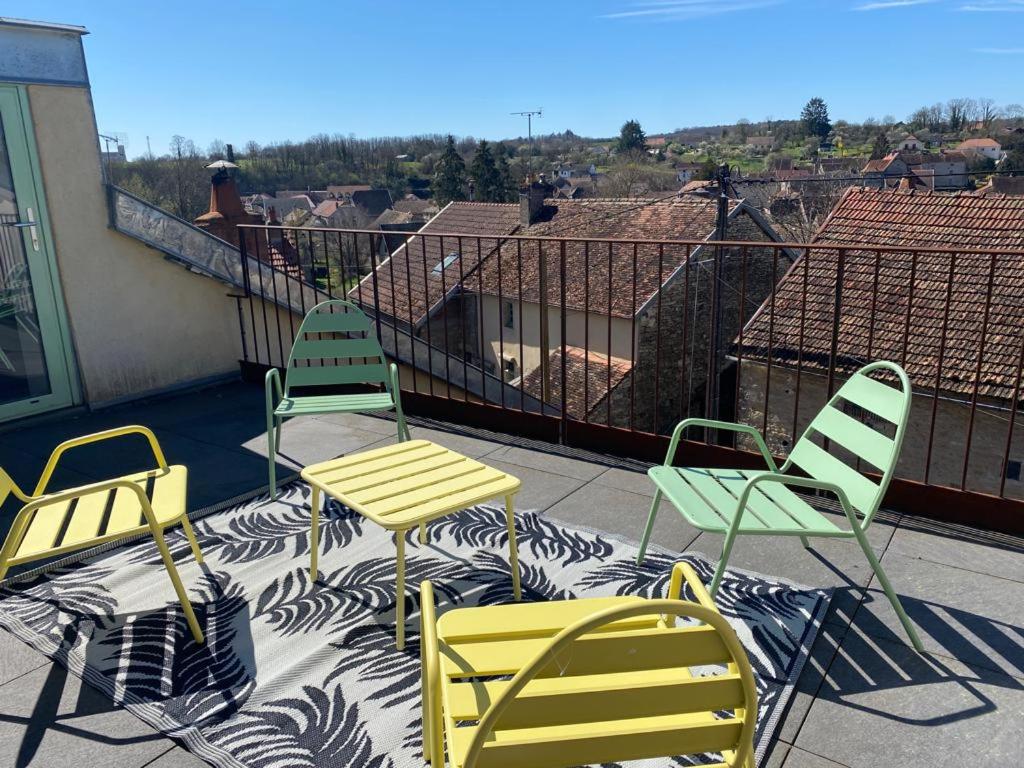un patio con sillas y mesas en un balcón en La chambrette en Bèze