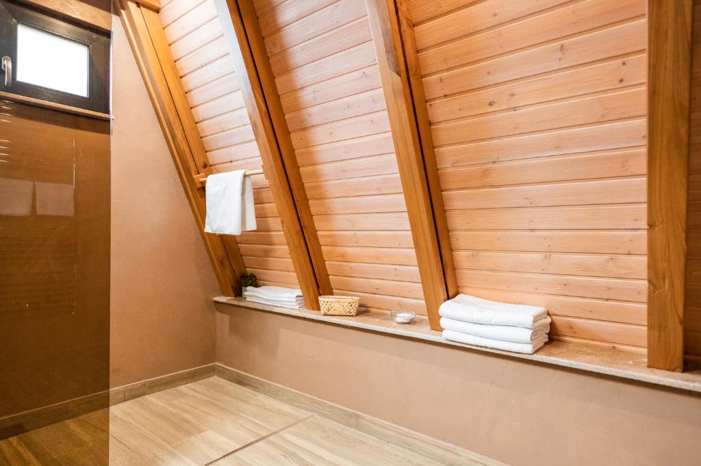 a bathroom with a sauna with towels on a shelf at Aruna Bran in Bran