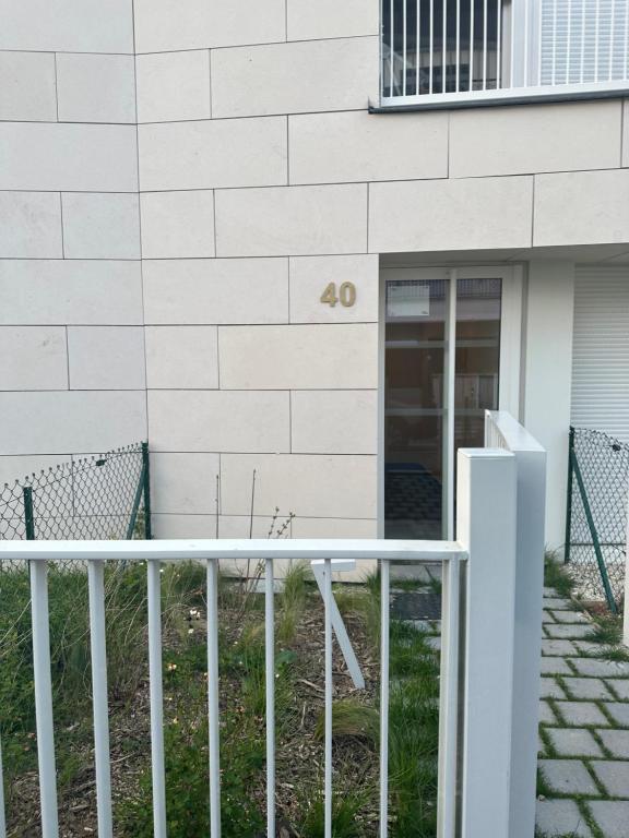 a white fence in front of a building at Myhotel19 in Noisy-le-Grand