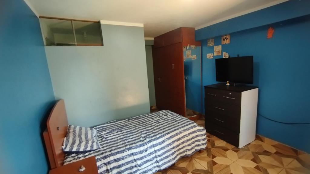 een slaapkamer met een bed en een tv op een dressoir bij DEPA OSAMA in Ayacucho