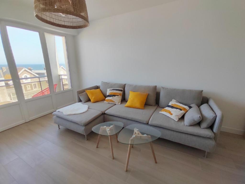 a living room with a gray couch with yellow pillows at Ker Romain - Sea View - 3 bedrooms Appt in Saint Malo