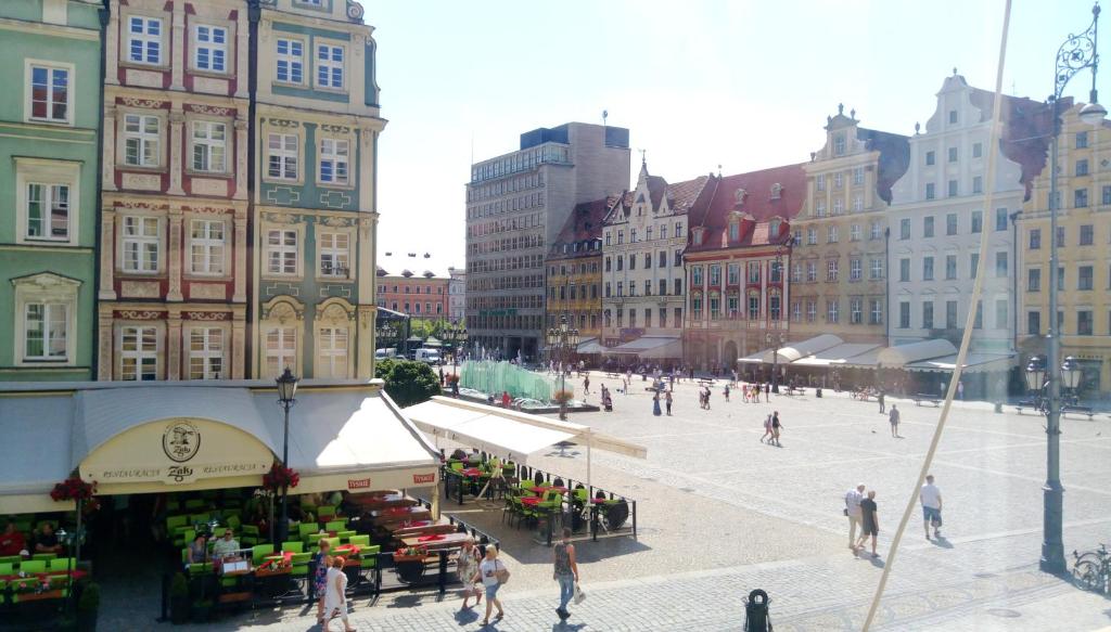 a group of people walking around a market in a city at Happy Apartments - Economy in Wrocław