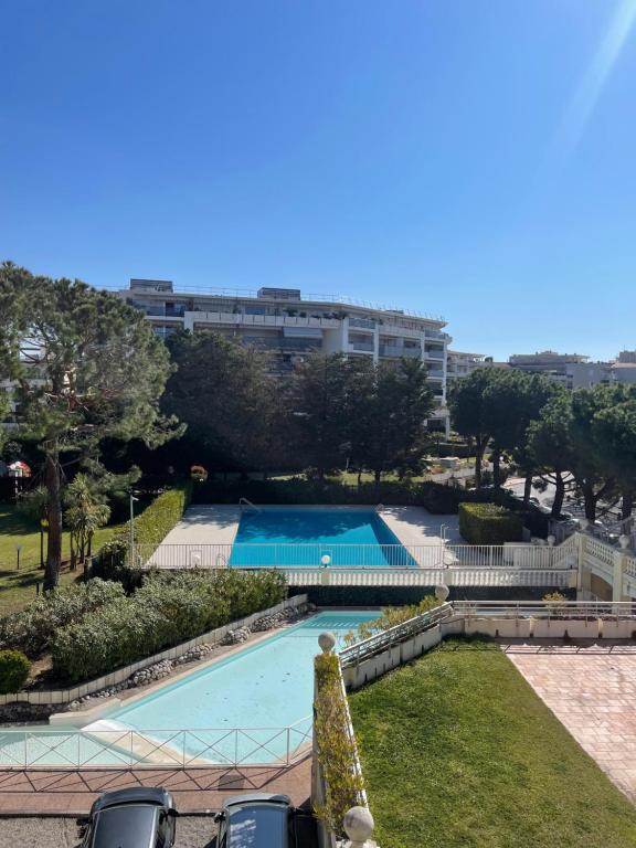 une piscine dans un parc avec un bâtiment en arrière-plan dans l'établissement appartement bord de mer avec piscine, à Cagnes-sur-Mer