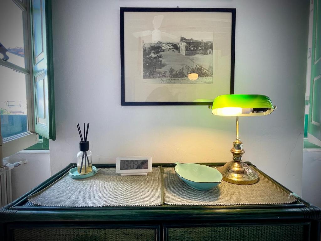 einen Tisch mit einer Lampe und einer Schüssel darauf in der Unterkunft Forte 43 in Forte dei Marmi