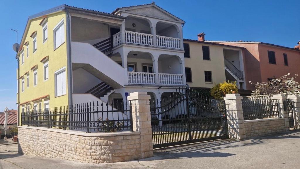 una grande casa con una recinzione in ferro battuto di Guest House Casa Mia - Rooms & Apartments a Rovigno (Rovinj)