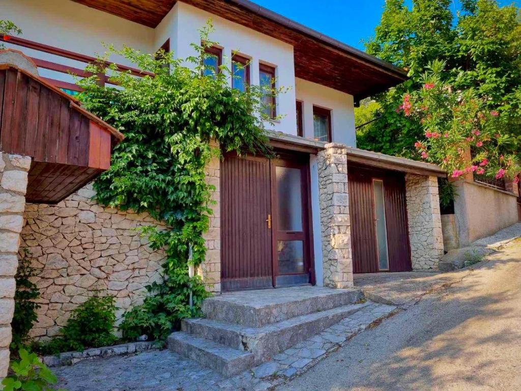 una casa con escaleras que conducen a una puerta de madera en Villa Tajra Stolac, en Stolac