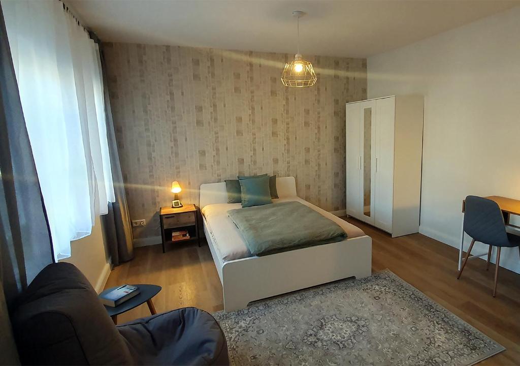 a bedroom with a bed and a couch and a table at Elegante Einzimmerwohnung in Flensburg