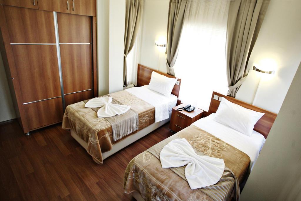 イスタンブールにあるTaksim Palace Hotelのベッド2台と窓が備わるホテルルームです。