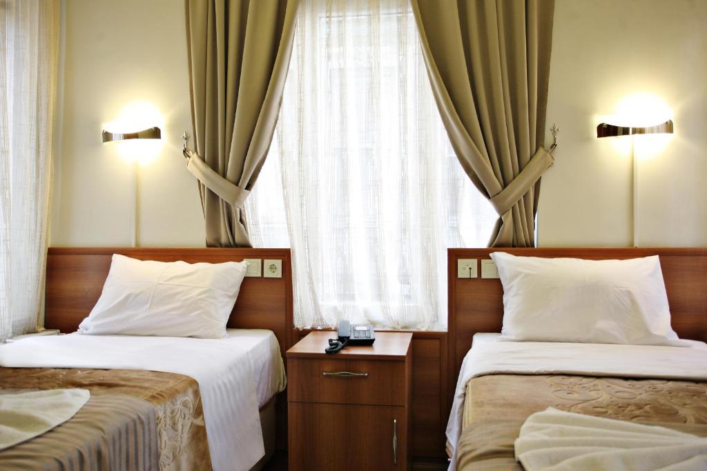 Postel nebo postele na pokoji v ubytování Taksim Palace Hotel