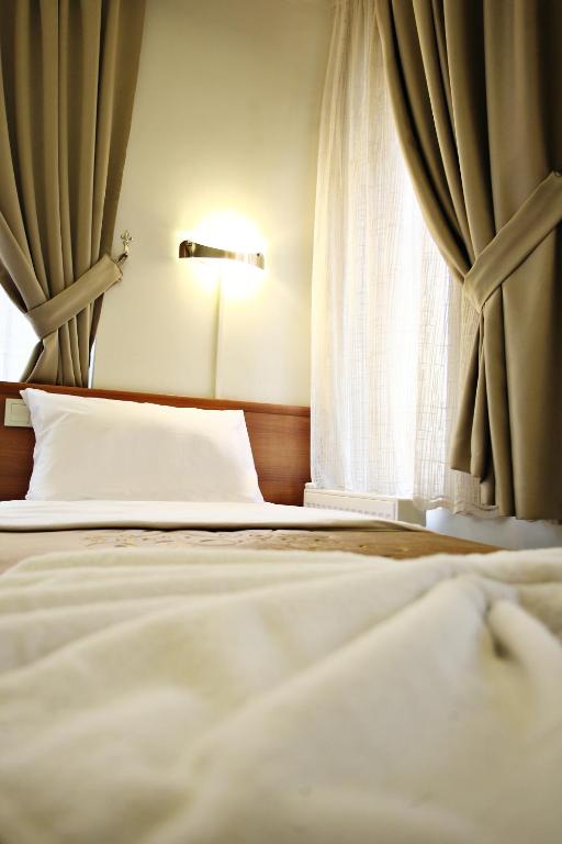 Postel nebo postele na pokoji v ubytování Taksim Palace Hotel