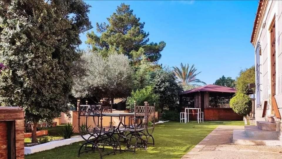 a garden with a table and chairs in a yard at rincones con encanto 