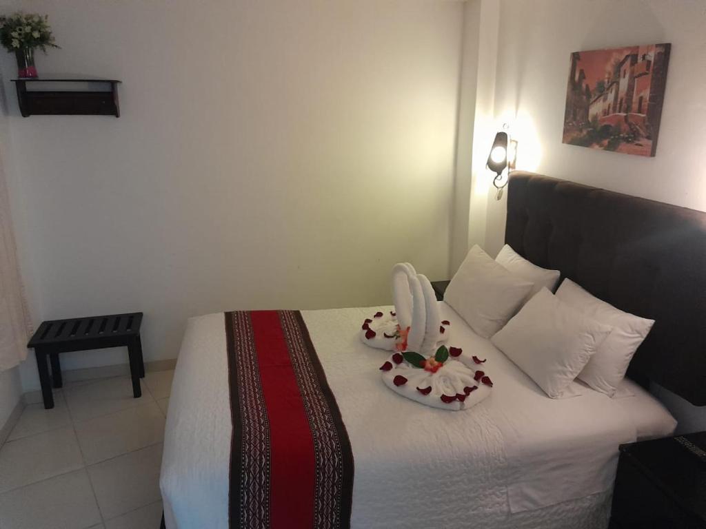 Un dormitorio con una cama con dos platos. en Margarita's House Machupicchu, en Machu Picchu