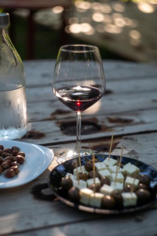 a glass of wine sitting next to a plate of food at Hotel Borklad in Berat