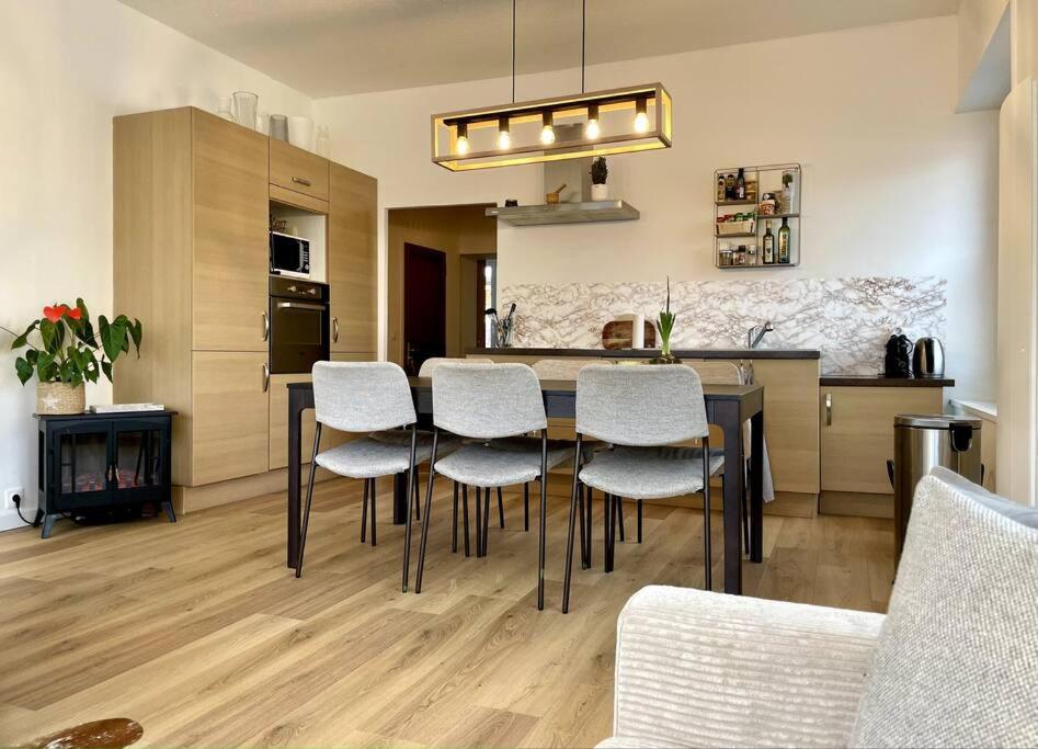 une cuisine avec une table et des chaises dans une pièce dans l'établissement Chaleureux appartement entre lac et montagne, à Neuvecelle