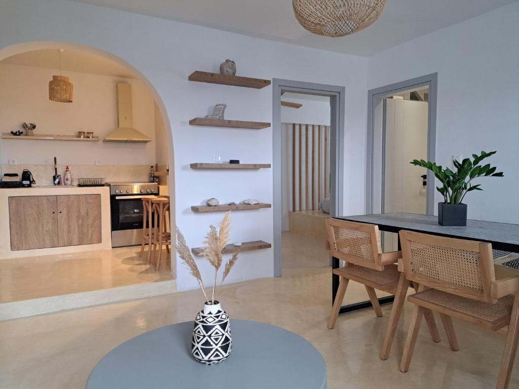 cocina y sala de estar con mesa y sillas en Charming Cozy Suites, en Naxos Chora