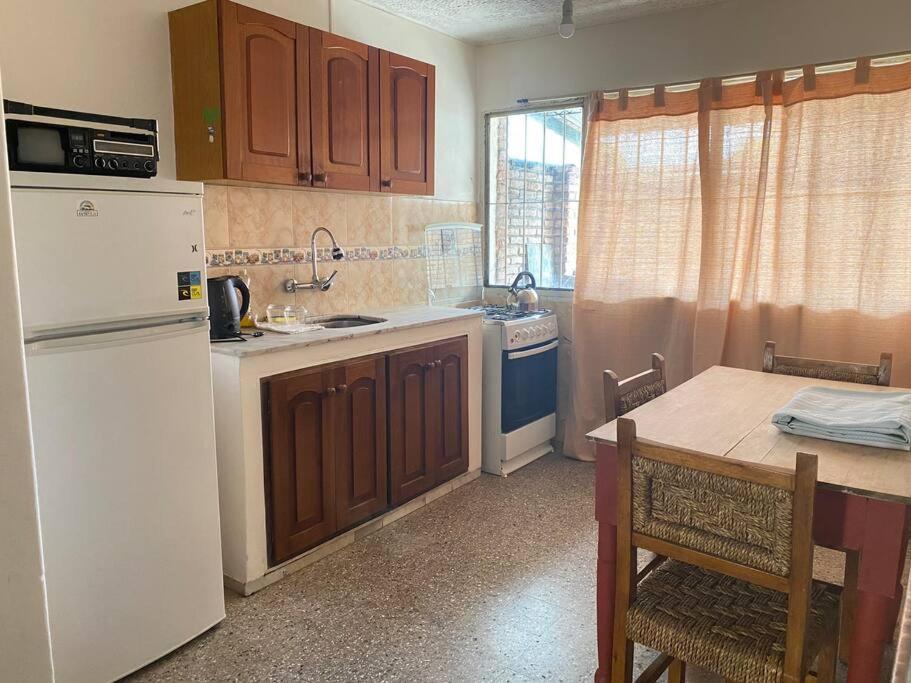 a kitchen with a white refrigerator and a table at Departamento vivienda completo in Carmelo