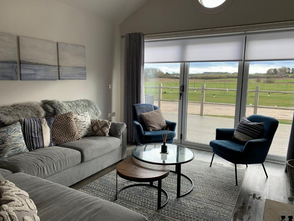 a living room with a couch and two chairs and a table at Seahorse Lodge at The Bay Filey, sleeps up to 6, and 2 dogs stay for free! in Filey