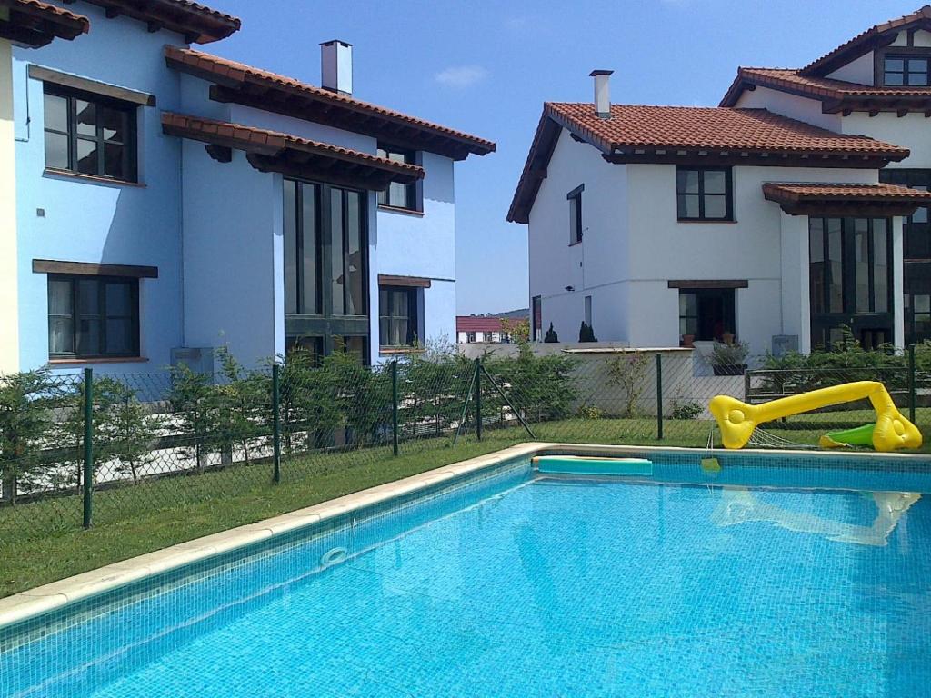 a swimming pool with a slide in front of two buildings at Duplex Colombres in Colombres