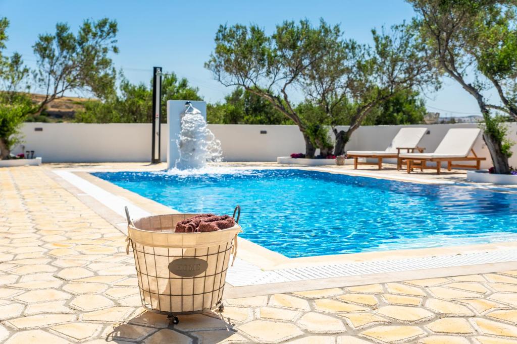 a basket next to a swimming pool with a fountain at Fantasy Rooms in Adamantas