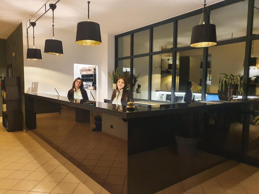 two women sitting at a counter in a restaurant at Tuo Hotel in Polignano a Mare