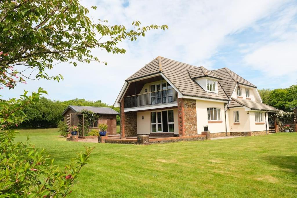 uma casa com um grande relvado em frente em Spacious North Devon villa with beautiful garden em Bideford