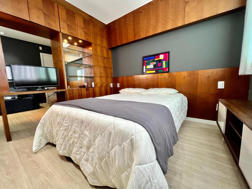 a bedroom with a bed and a flat screen tv at Flat em região nobre in Belo Horizonte