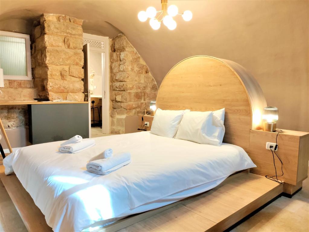 ein Schlafzimmer mit einem großen Bett mit zwei Handtüchern darauf in der Unterkunft Mina Boutique in Jerusalem