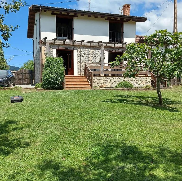 a house with a grass yard in front of it at La Quintana de Mary in Aramil de Arriba