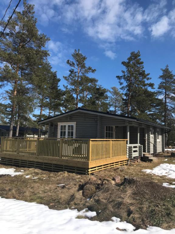 ein Blockhaus mit einer Veranda im Schnee in der Unterkunft Bastöstugby stuga 17 in Pålsböle