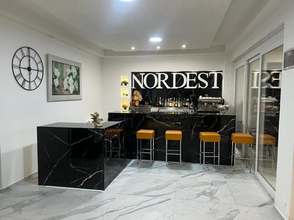a bar with yellow bar stools in a room at Hotel Nord Est in Riccione