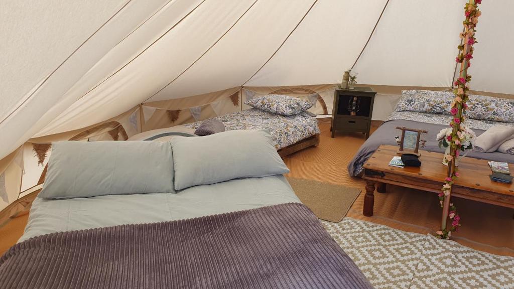 1 dormitorio con 2 camas en una tienda de campaña en Calon Y Goedwig Glamping, en Llandovery